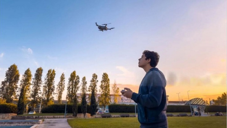 Man piloting a droneduring sunset.
