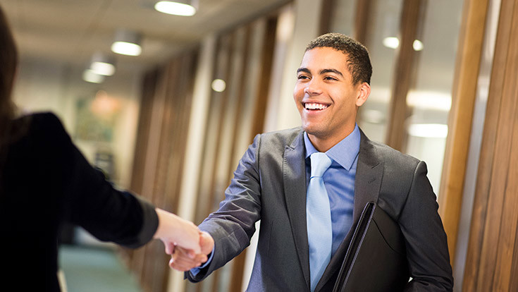 Student in suit shaking hands